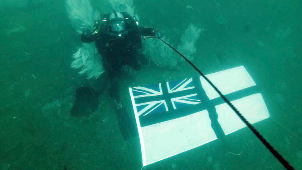 RN Diver 'flies' the RN standard on HMS Hermes